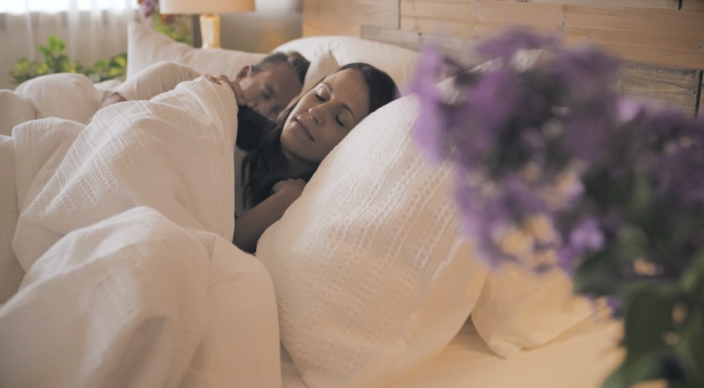 Chiropractor and wife sleeping in a Harbor Springs Mattress while filming for a positive testimonial.