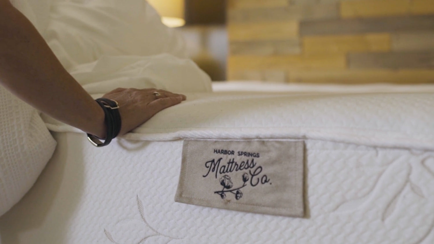 hand on cozy mattress in the store of Harbor Springs Mattress Company in Harbor Springs, Michigan