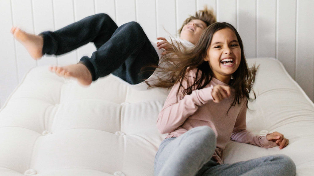 Children playing in bed demonstrating how durable a Harbor Springs Mattress bed is.