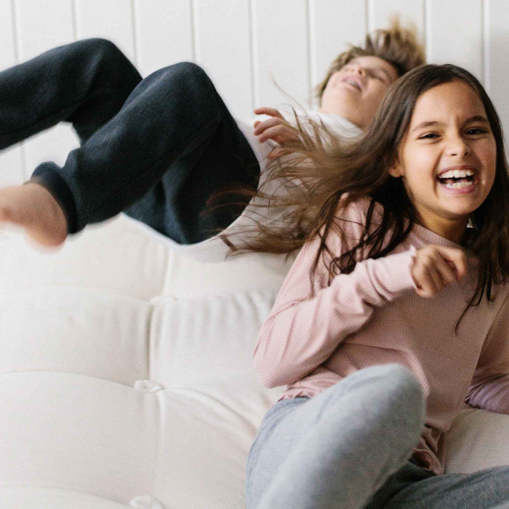 Children playing and jumping on a bed demonstrating how durable a Harbor Springs Mattress Co. bed is.