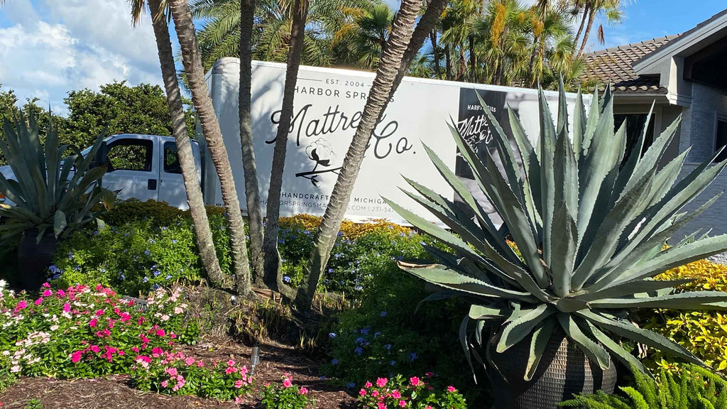 Harbor Springs Mattress Delivery Truck in a driveway with flowers in the garden.