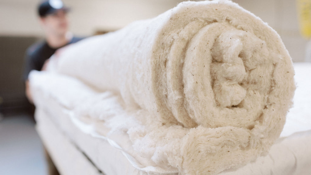 organic cotton is rolled up and ready to be placed on a luxury mattress.