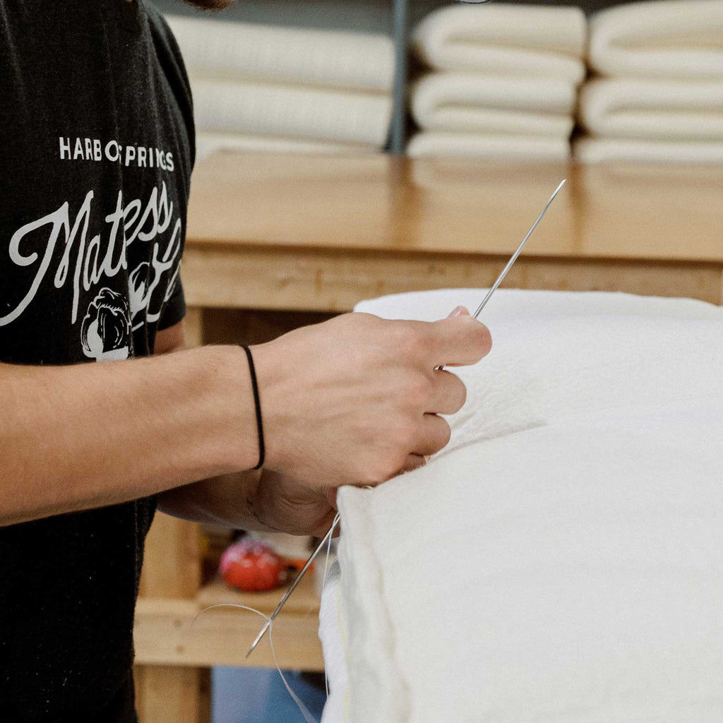 Craftsman hand-stitching a luxury mattress at Harbor Springs Mattress Company