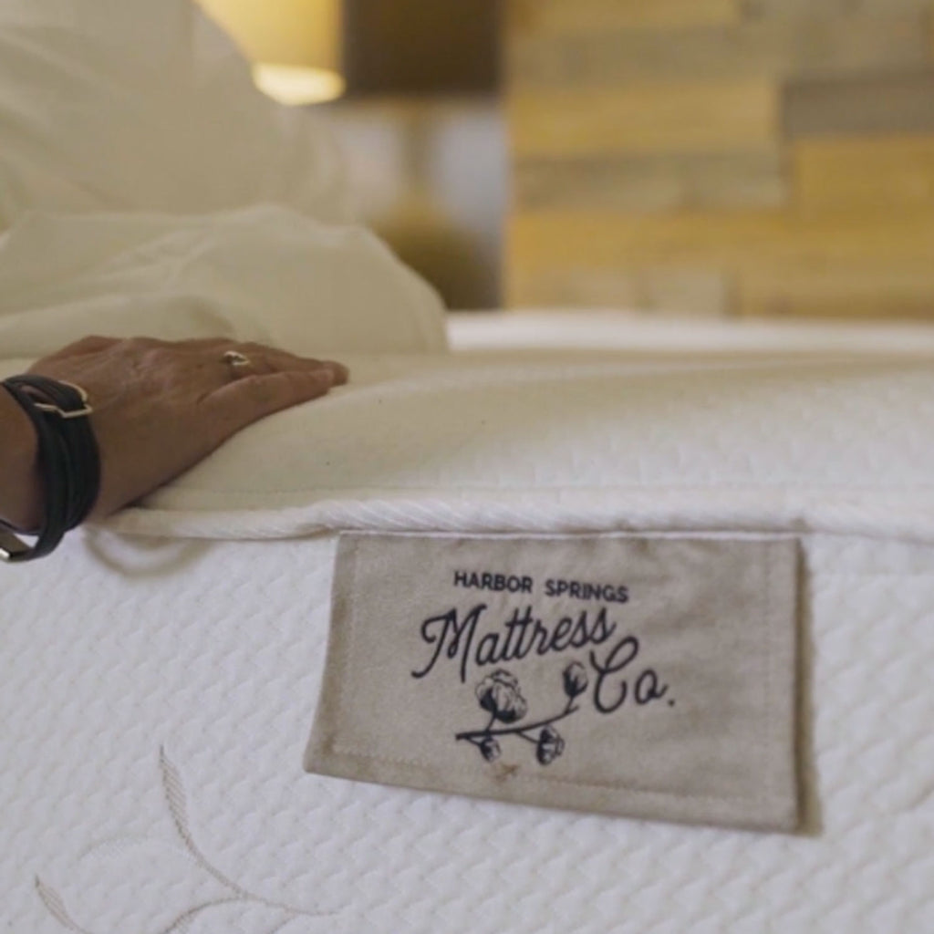 hand on cozy mattress in the store of Harbor Springs Mattress Company in Harbor Springs, Michigan