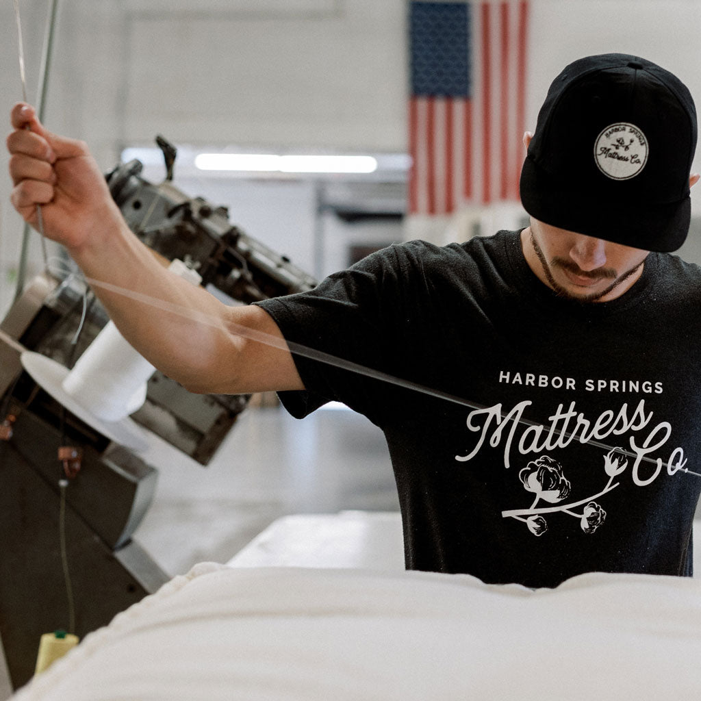 Craftsman hand sewing a luxury mattress in the workshop of Harbor Springs Mattress Co. in Harbor Springs, Michigan.