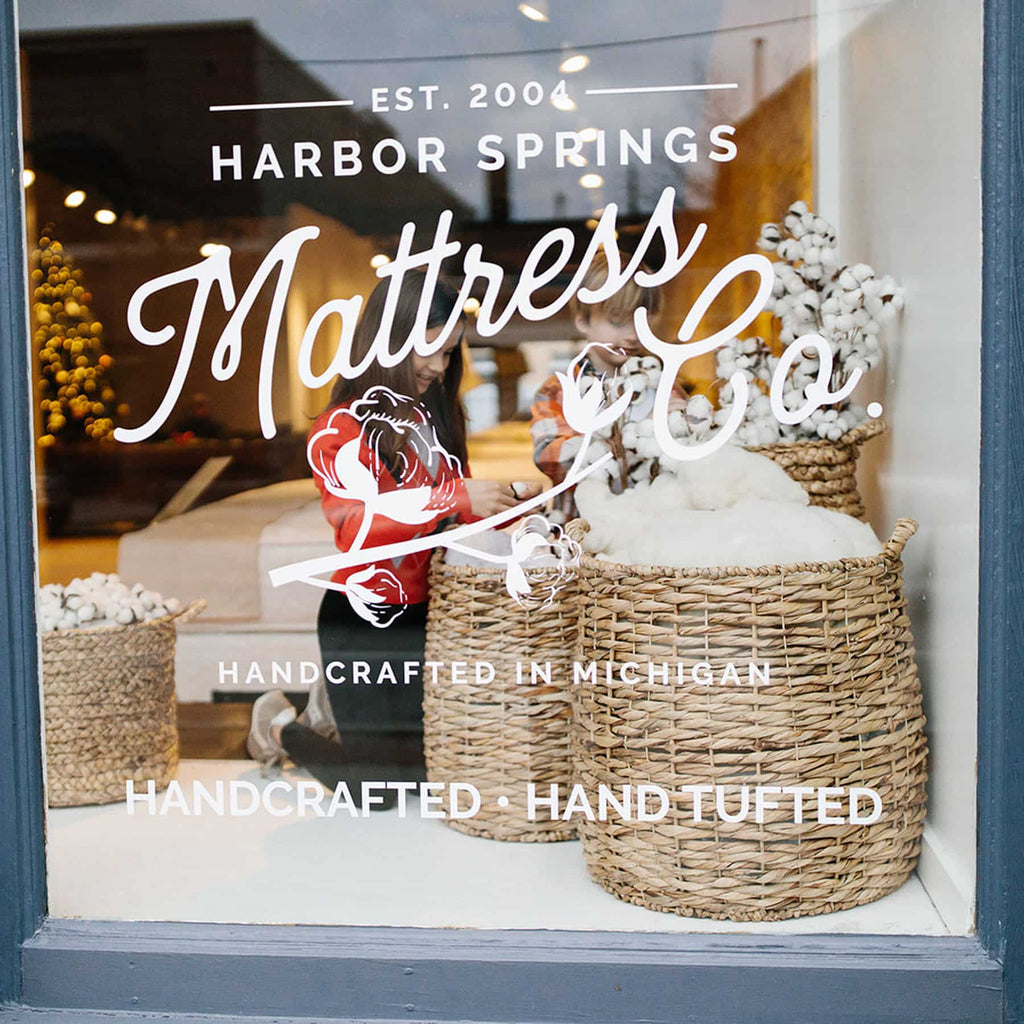 Children touching the natural fibers in the window display at the Traverse City Mattress Store.